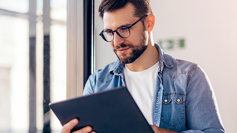 Man reading a tablet by the window