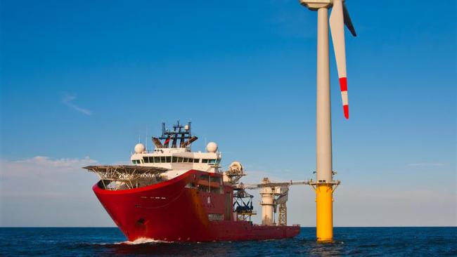 Offshore vessel at sea with wind turbine